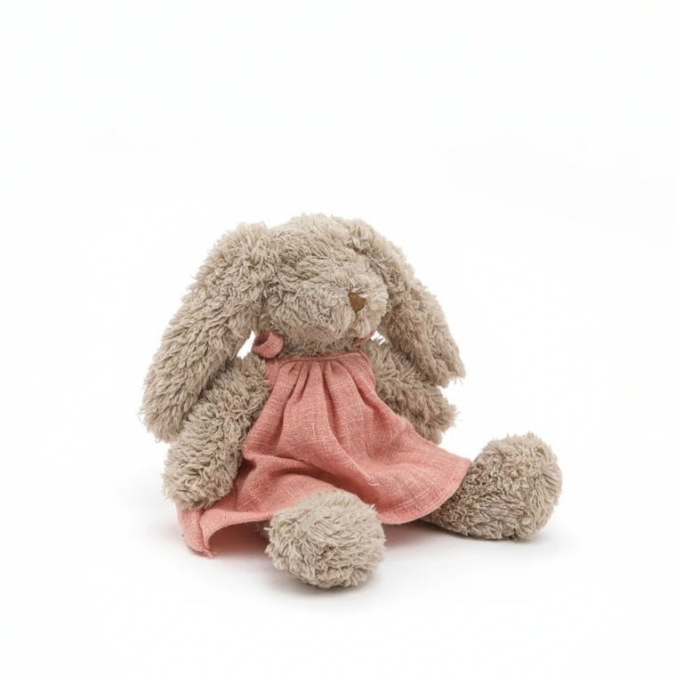 Plush bunny toy with a pink dress on a white background