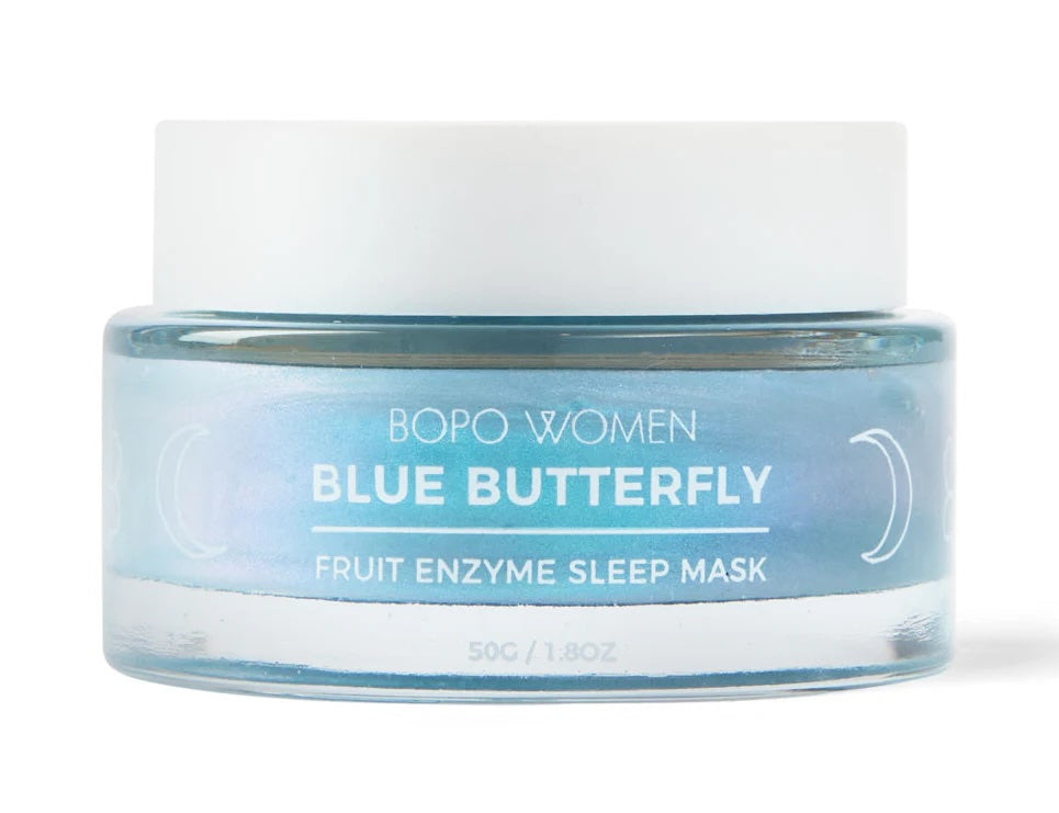 Jar of 'Blue Butterfly' fruit enzyme sleep mask on a light blue background