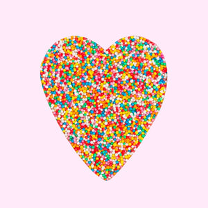 Chocolate freckle heart-shape on a light pink background