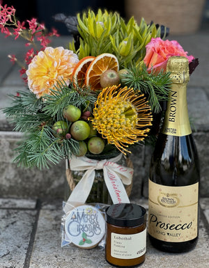 Hamper with sparkling wine, flowers in a vase, cookie and candle, in a lovely gift box.