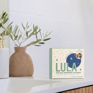 Eucalyptus self-warming eye mask on a shelf with a vase and plant in the background