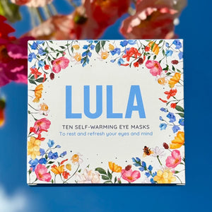 Self-warming eye masks packaging with floral design on a blue background.