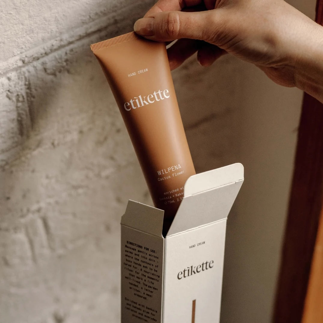 Tube of Wilpena hand cream against a yellow and beige background.