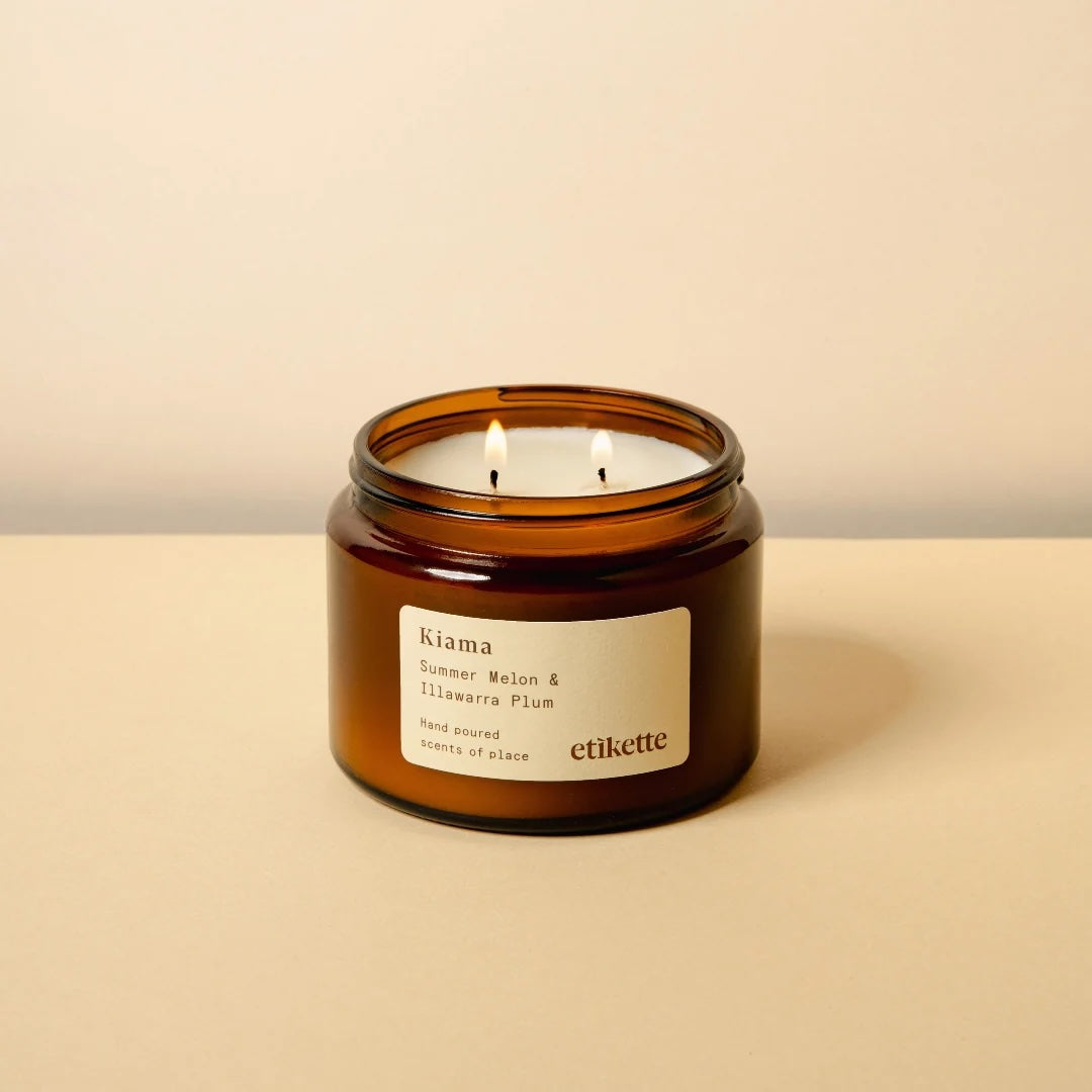 Kiama scented double wick candle in a brown glass jar with a label on a beige background