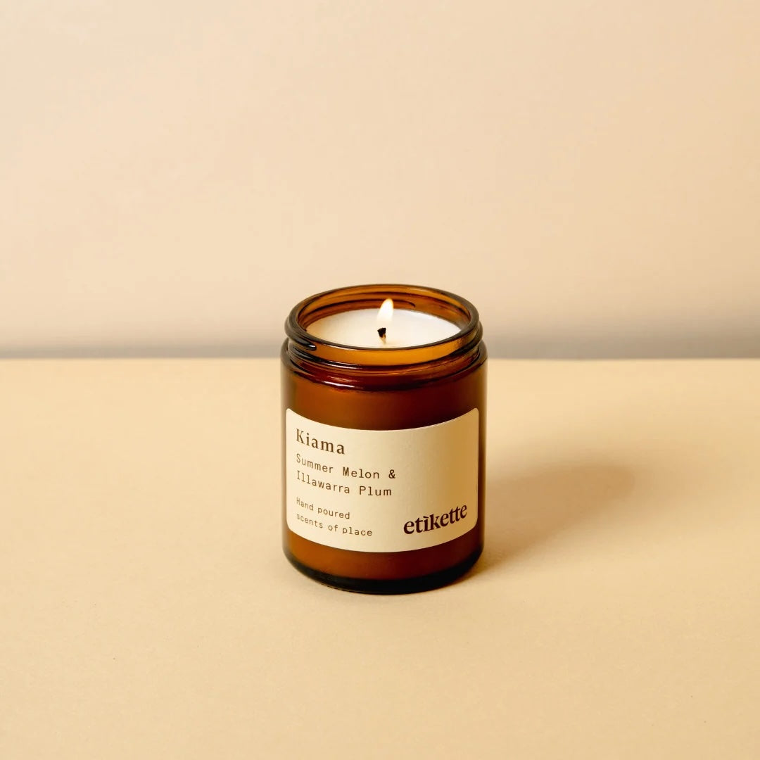 Kiama scented double wick candle in a brown glass jar with a label on a beige background
