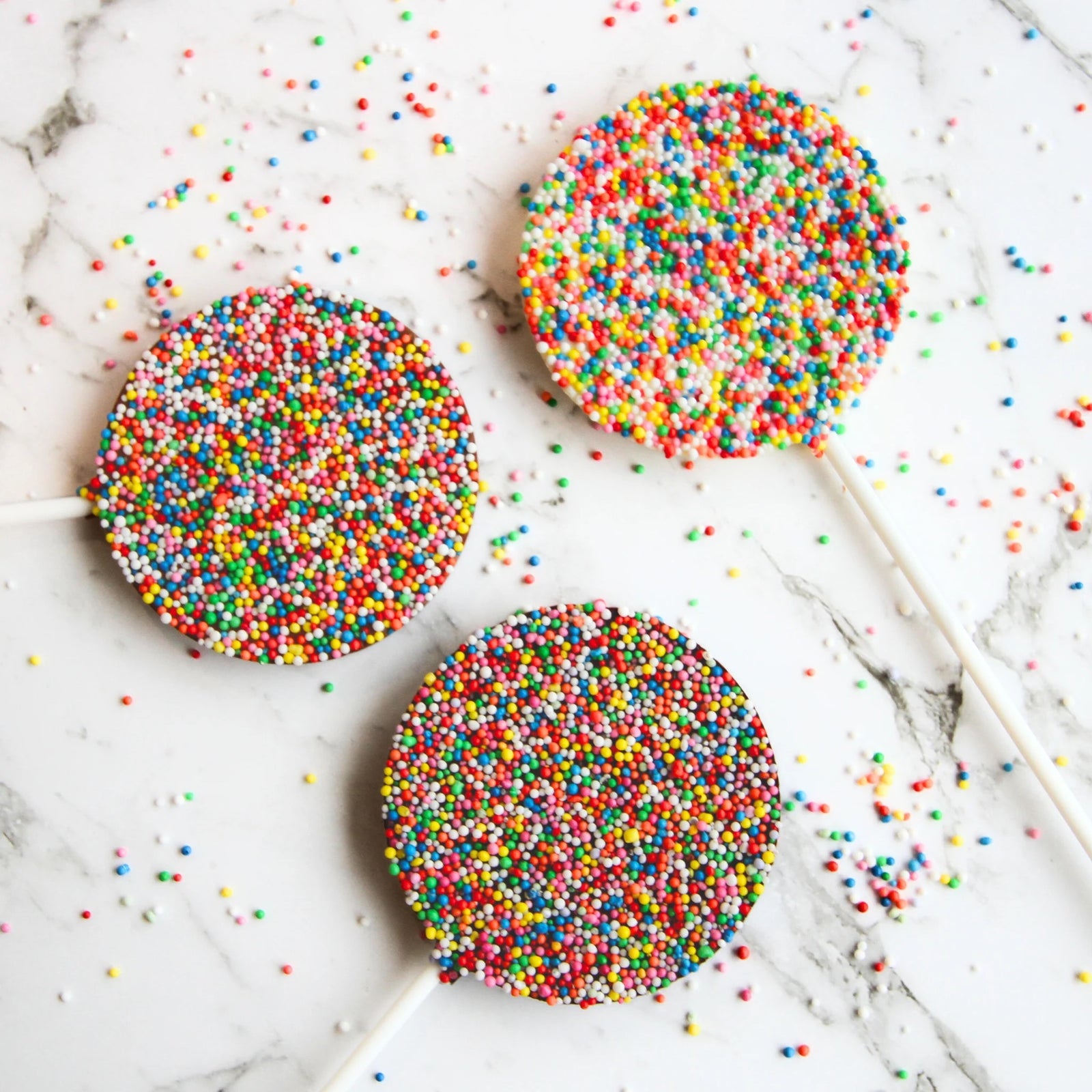 Milk chocolate round freckle lollipops.