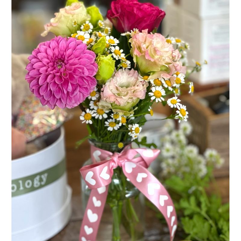 Hamper for Valentine's Day with a plus teddy bear, a bouquet of flowers in a reusable clear glass vase and a bottle of prosecco.