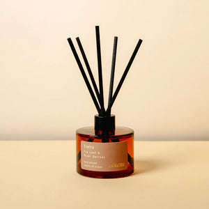 A Yarra eco reed diffuser in Fig Leaf and River Berries, with a brown glass jar and a black lid.